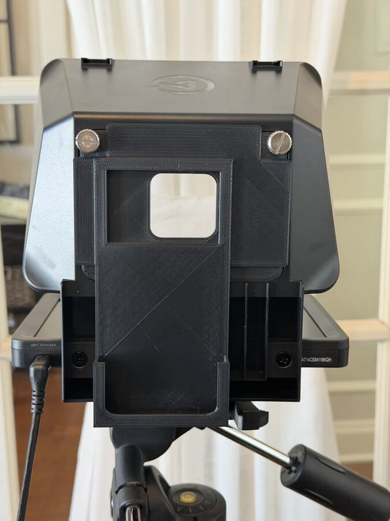 The completed 3D printed backplate mounted on the back of the Elgato Prompter. The iPhone 17 Pro sits securely in the frame with the camera aligned to the center opening.